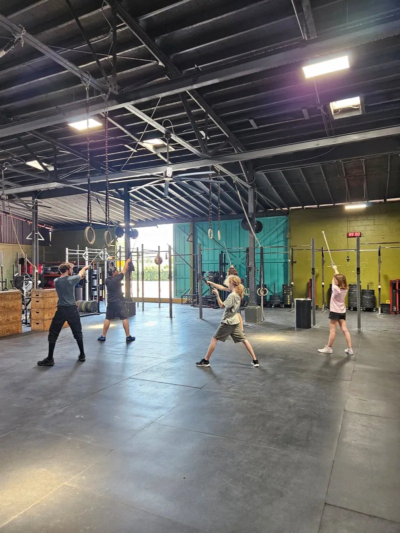 Teens being led through longsword stances.